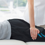 Physiotherapist working on the leg of young man