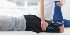 Physiotherapist working on the leg of young man